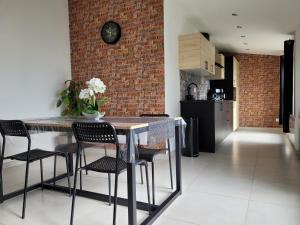 a kitchen with a table and chairs and a brick wall at Il Vialetto , appartement Milano , spacieux, tout confort, au calme in Jeumont