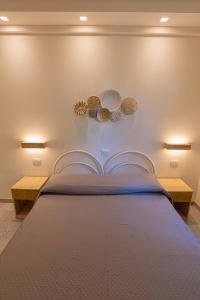 a bedroom with a bed with two tables and plates on the wall at Residence Ranieri in Castiglione del Lago