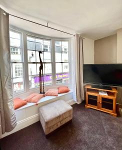 a living room with a window seat with a tv at Gigi's Place in Weymouth