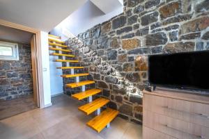 Televízia a/alebo spoločenská miestnosť v ubytovaní TerraZeus - Stone House Beachfront 1
