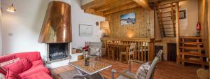 - un salon avec un canapé et une cheminée dans l'établissement Madame Vacances Chalet Val Rogoney, à Val dʼIsère