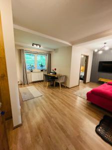 a living room with a red bed and a table at Apartament Góry i Potok in Porąbka