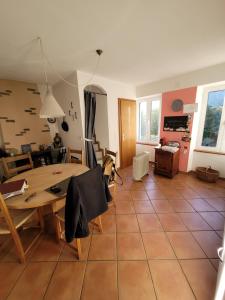 una cucina e un soggiorno con tavolo e sedie di Casa Hürlimann a Breno