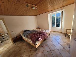 - une chambre avec un lit dans une pièce dotée d'une fenêtre dans l'établissement Casa Hürlimann, à Breno