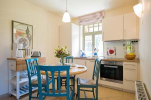 een keuken met blauwe stoelen en een tafel in een keuken bij Ferienhaussiedlung Strandperlen Küstenhof 2d (Typ IV) in Wustrow