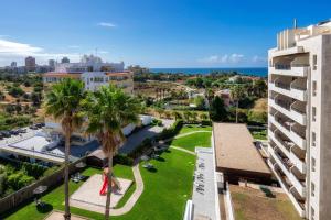 an aerial view of a city with palm trees and the ocean at Ocean view apartment in Portimão