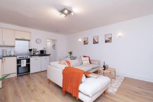 sala de estar con sofá blanco y cocina en Content-Living, en Cheltenham