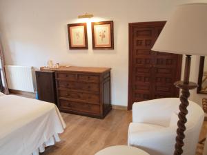 1 dormitorio con cómoda, silla y lámpara en Molino Del Santo, en Benaoján
