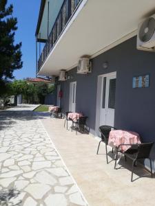a patio with chairs and a building with a staircase at Anestis Studios in Agios Georgios