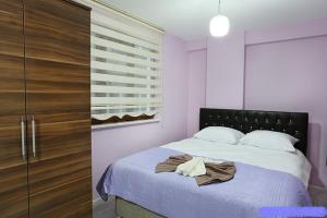 a bedroom with a bed and a wooden closet at Yıldız Pansiyon in Amasra