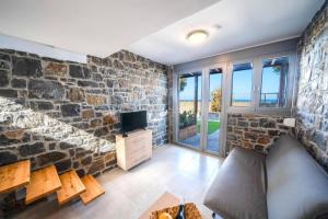 - un salon avec un mur en pierre et un canapé dans l'établissement TerraZeus - Stone House Beachfront 2, à Milatos