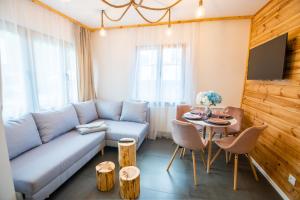- un salon avec un canapé et une table dans l'établissement Apart Invest Fanaberia, à Szklarska Poręba