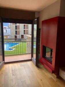 a living room with a fireplace and a balcony at Precioso apartamento con piscina, ideal familias! in Sort