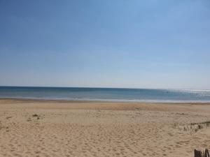 einen Sandstrand mit dem Ozean im Hintergrund in der Unterkunft La belle Vendéenne in La Tranche-sur-Mer