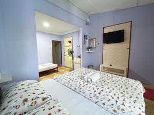 una camera con letto e parete blu di Merdeka Guest House 2 a Kuching