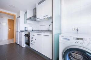 a kitchen with a washing machine and a washer at Apartamento con terraza privada y vistas al mar in Benidorm