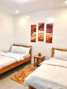 a bedroom with two beds and a rug at Nord House Laoag in Laoag