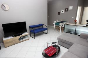 uma sala de estar com um sofá e uma televisão em Apartments Fjolla em Labin