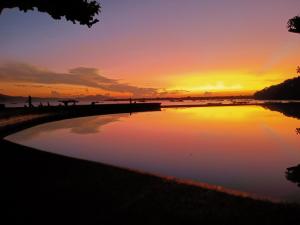 una puesta de sol sobre un cuerpo de agua en Tamarind Beach Bungalow, en Nusa Lembongan