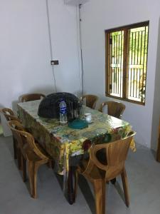 - une table avec des chaises et une bouteille d'eau dans l'établissement Joes resthouse, à Oddaimavadi