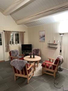 uma sala de estar com uma mesa e cadeiras e uma televisão em Hytte i nydelige Jotunhemen - rett ved Besseggen em Randsverk
