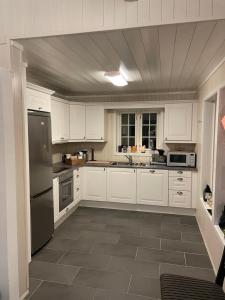 a kitchen with white cabinets and stainless steel appliances at Hytte i nydelige Jotunhemen - rett ved Besseggen in Randsverk