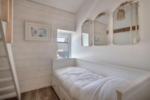 a small bedroom with two mirrors and a bed at Ty Maria Havre de douceur et de calme au coeur de la ville haute de Pornic in Pornic