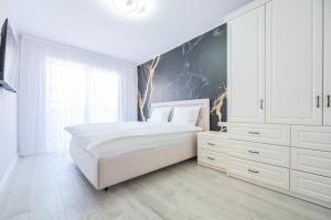 1 dormitorio blanco con 1 cama grande y armarios blancos en Ceyrat Flat en Oradea