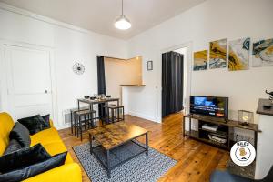 ein Wohnzimmer mit einem gelben Sofa und einem TV in der Unterkunft CEDICI Ideal Couples ou Famille - Moderne in Pau