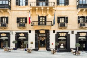 a building with tables and chairs in front of it at Rosselli AX Privilege in Valletta