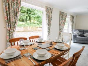 a dining room with a wooden table and chairs at Woodlands in Okehampton