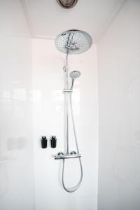 um chuveiro na casa de banho com uma cabeça de chuveiro em The Lion King - 6 Person linked apartment with roof terrace em Groningen