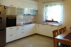 una cocina con armarios blancos y un aparato negro en Happy Apartments Biograd, en Opatijski Torovi