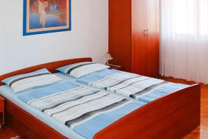 1 dormitorio con 1 cama con sábanas azules y blancas en Happy Apartments Biograd, en Opatijski Torovi