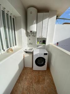 a small kitchen with a washing machine and a sink at Casa Luz De Alba in Calabardina