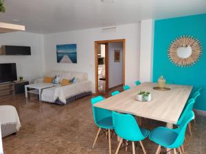 a dining room with a table and blue chairs at Casa Luz De Alba in Calabardina