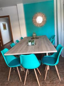 a dining room table with blue chairs and a mirror at Casa Luz De Alba in Calabardina