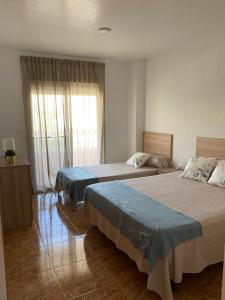 a hotel room with two beds and a window at Casa Luz De Alba in Calabardina +22 photos