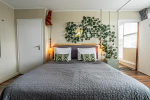 um quarto com uma cama grande e uma planta na parede em The Lion King - 6 Person linked apartment with roof terrace em Groningen