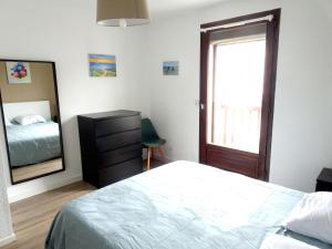 Schlafzimmer mit einem Bett, einer Kommode und einem Spiegel in der Unterkunft Charming maisonette in duplex, 400 m from the beach in Courseulles-sur-Mer