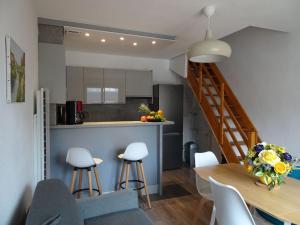 eine Küche und ein Esszimmer mit einer Treppe in einem Apartment in der Unterkunft Charming maisonette in duplex, 400 m from the beach in Courseulles-sur-Mer