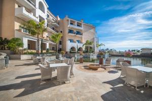 a patio with tables and chairs in front of a building at Stunning 2 Bedroom 2 Bathroom Town House - CE7LT in Roldán