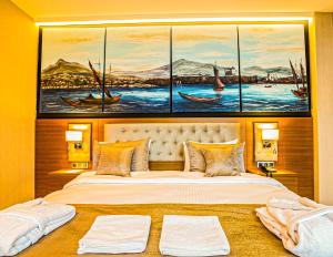 فندق Aselia Trabzon في طرابزون: غرفة نوم بسرير كبير عليها ثلاث لوحات