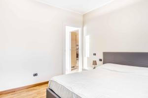 布斯托阿西齊奧的住宿－Residenza Liliana，白色卧室设有一张大床和镜子
