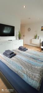 a large bed with two towels on top of it at Apartmenthaus Westerkoog in Hedwigenkoog