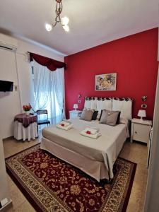 a bedroom with a large bed with a red wall at B&B Divina Roma in Rome