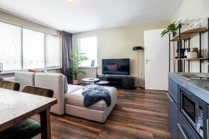 een woonkamer met een bank en een tv bij The Lion King - 6 Person linked apartment with roof terrace in Groningen
