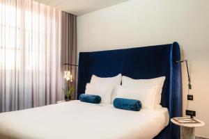 a bedroom with a large bed with a blue headboard at Rosselli AX Privilege in Valletta
