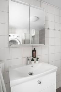 a white bathroom with a sink and a mirror at Forenom Hotels & Apartments Flemingsberg - 10min from Älvsjö in Huddinge +29 photos