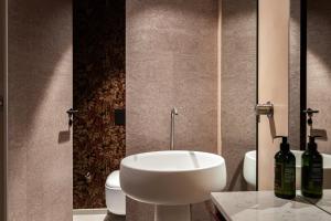 a bathroom with a white sink and two bottles of wine at Rosselli AX Privilege in Valletta